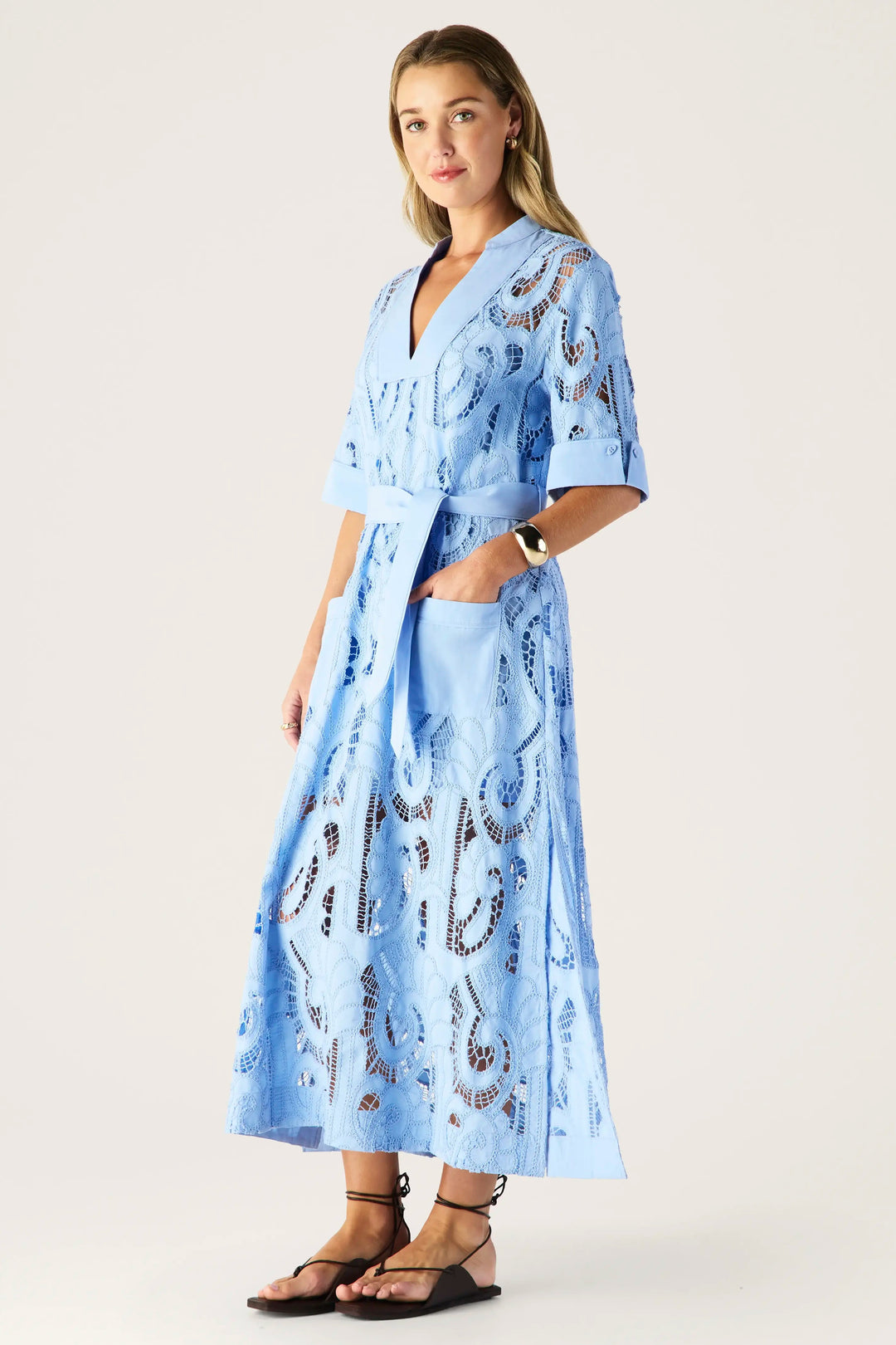 Woman wearing a light blue dress with a pattern on a white background