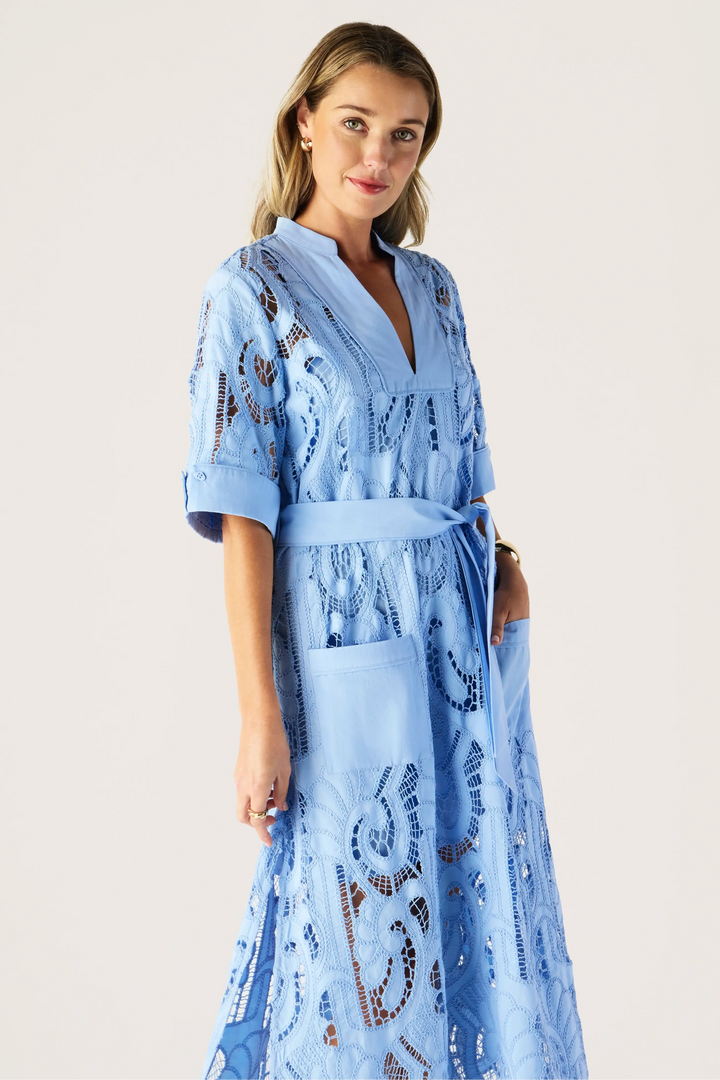 Woman wearing a blue lace robe against a plain background
