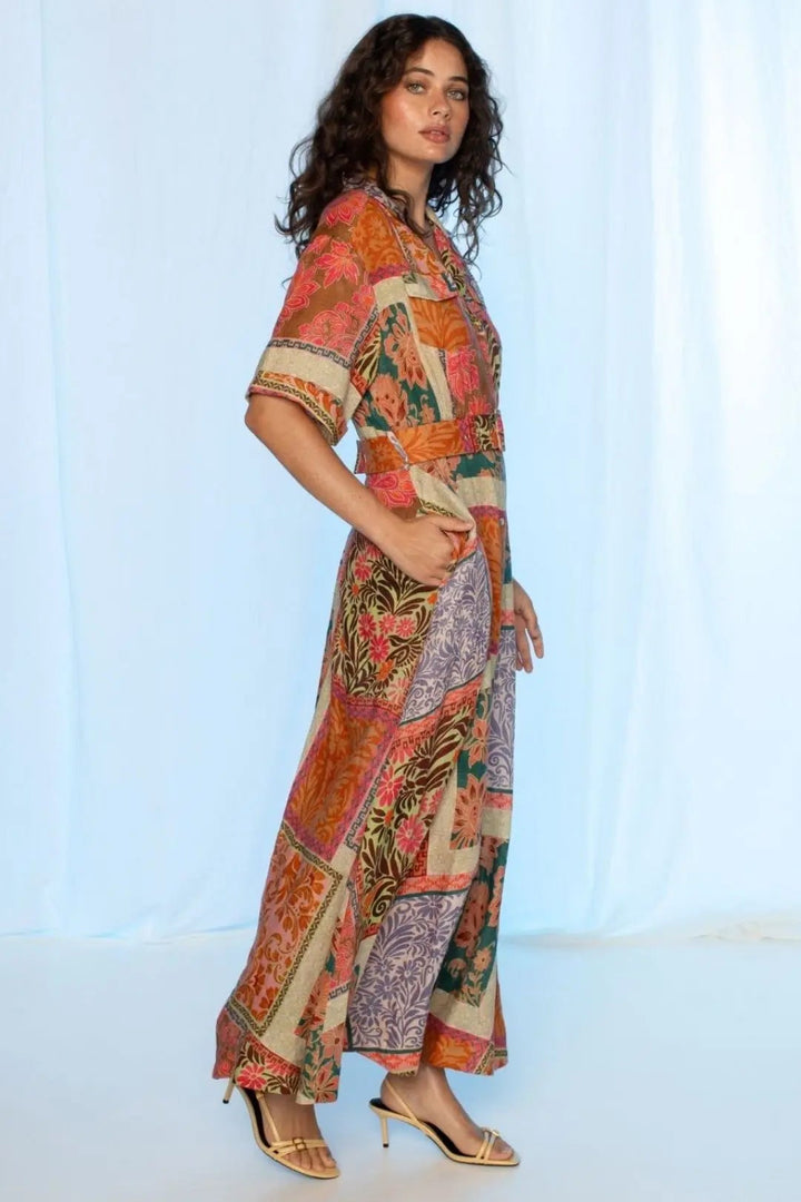 Woman wearing a colorful patterned outfit against a white background