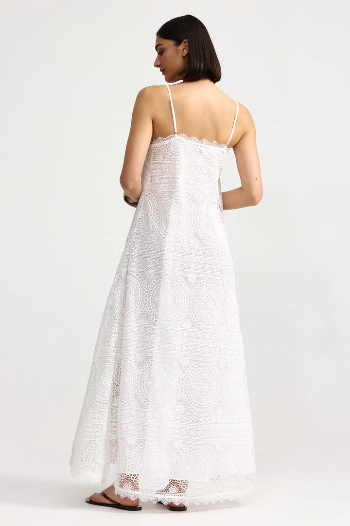Woman wearing a white dress with thin straps on a plain background. Willow Dress Antique