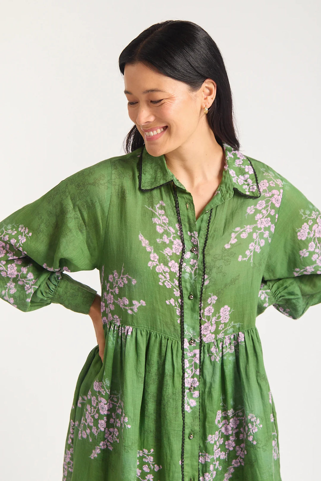Woman wearing a green floral dress on a white background