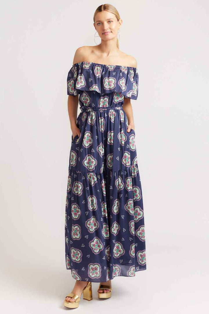Woman wearing a blue floral off-shoulder dress on a white background