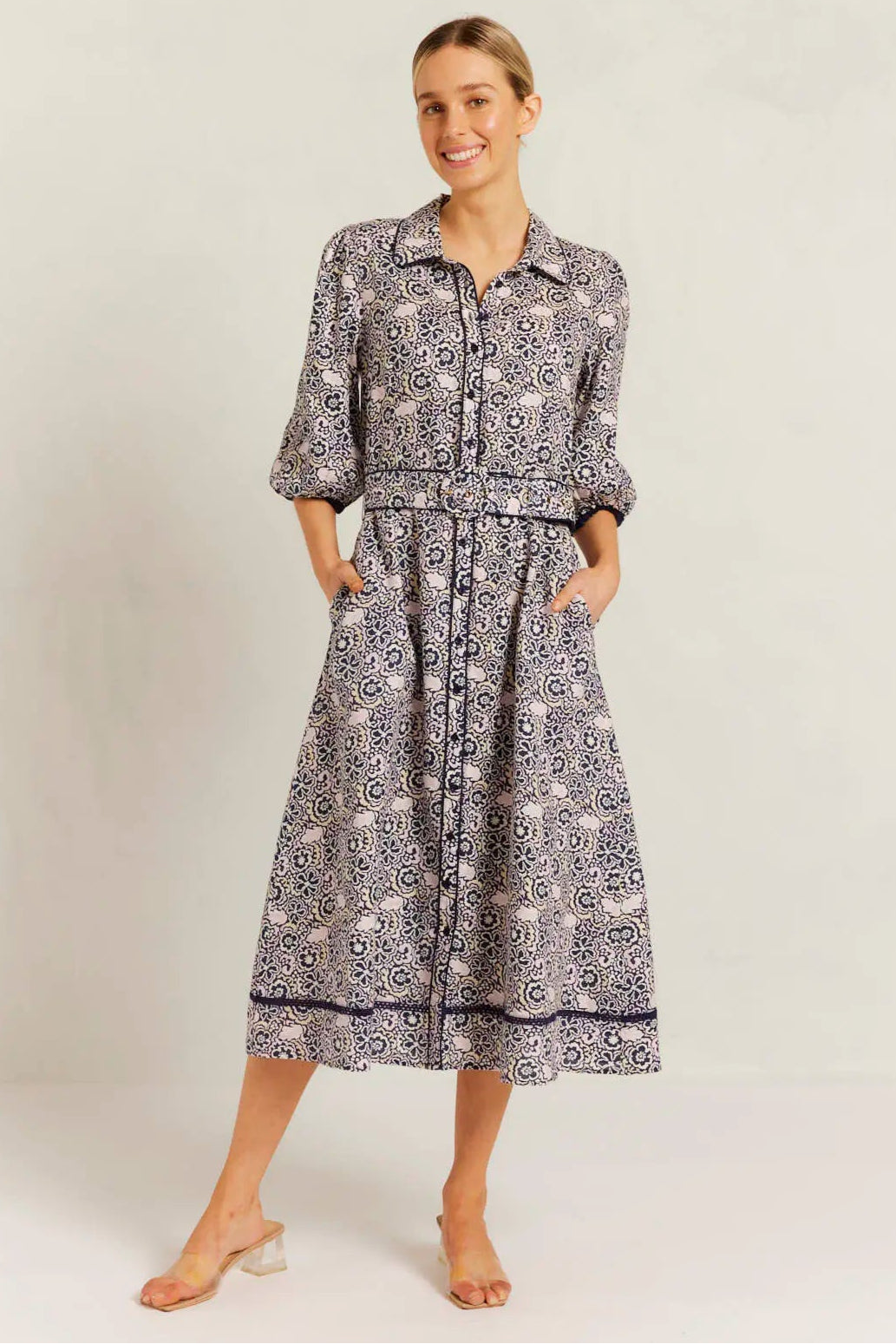 Woman wearing a patterned dress and shirt set on a white background