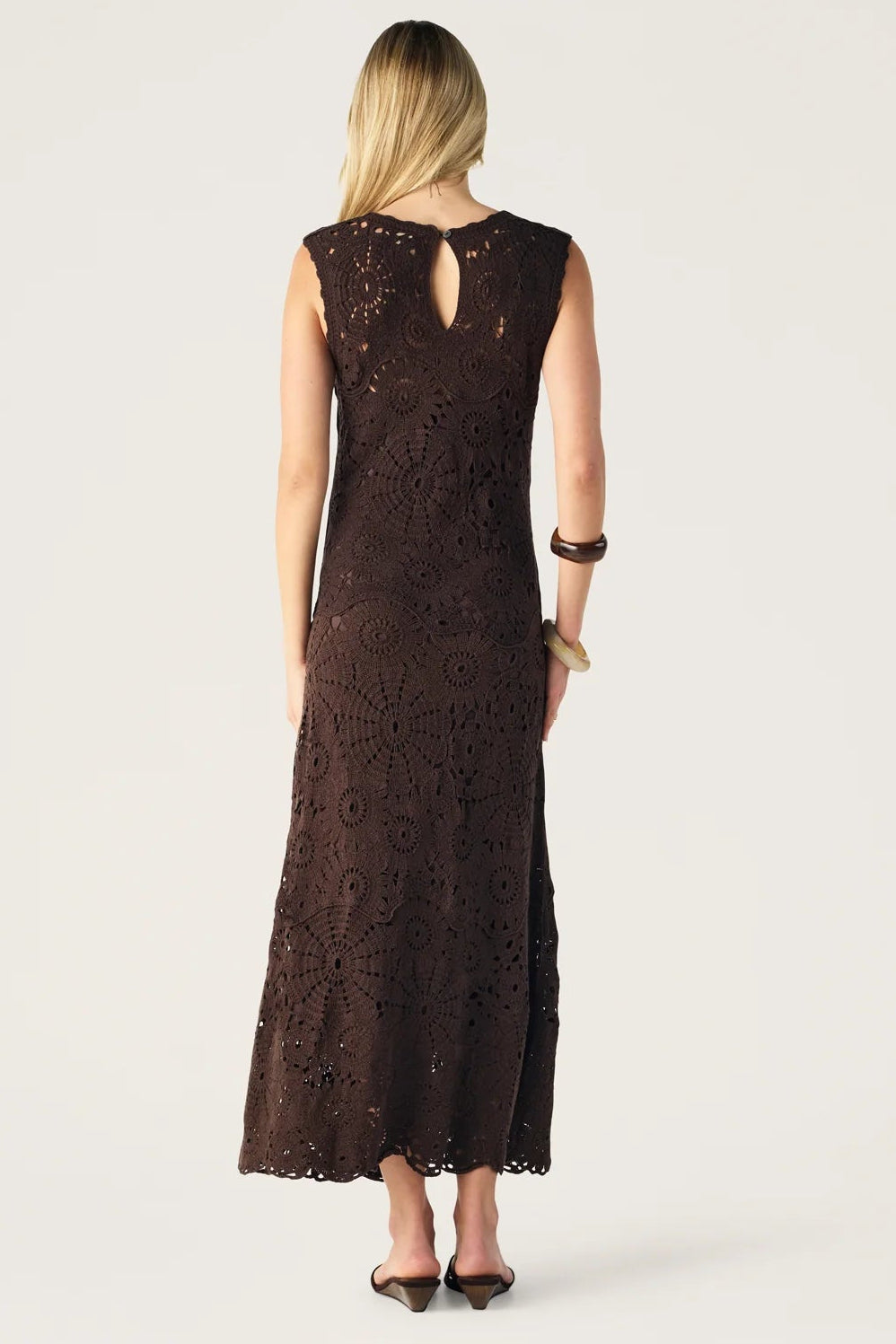 Woman wearing a brown lace dress on a white background