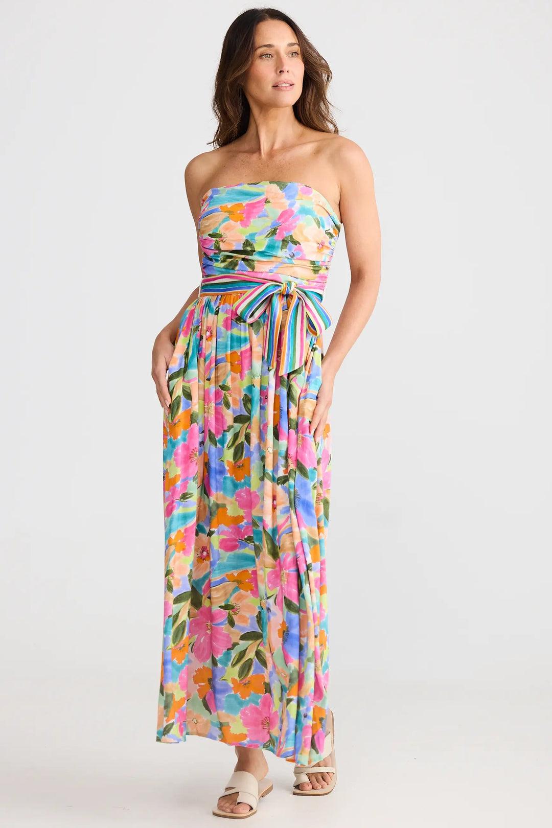 Woman wearing a colorful floral strapless dress on a white background
