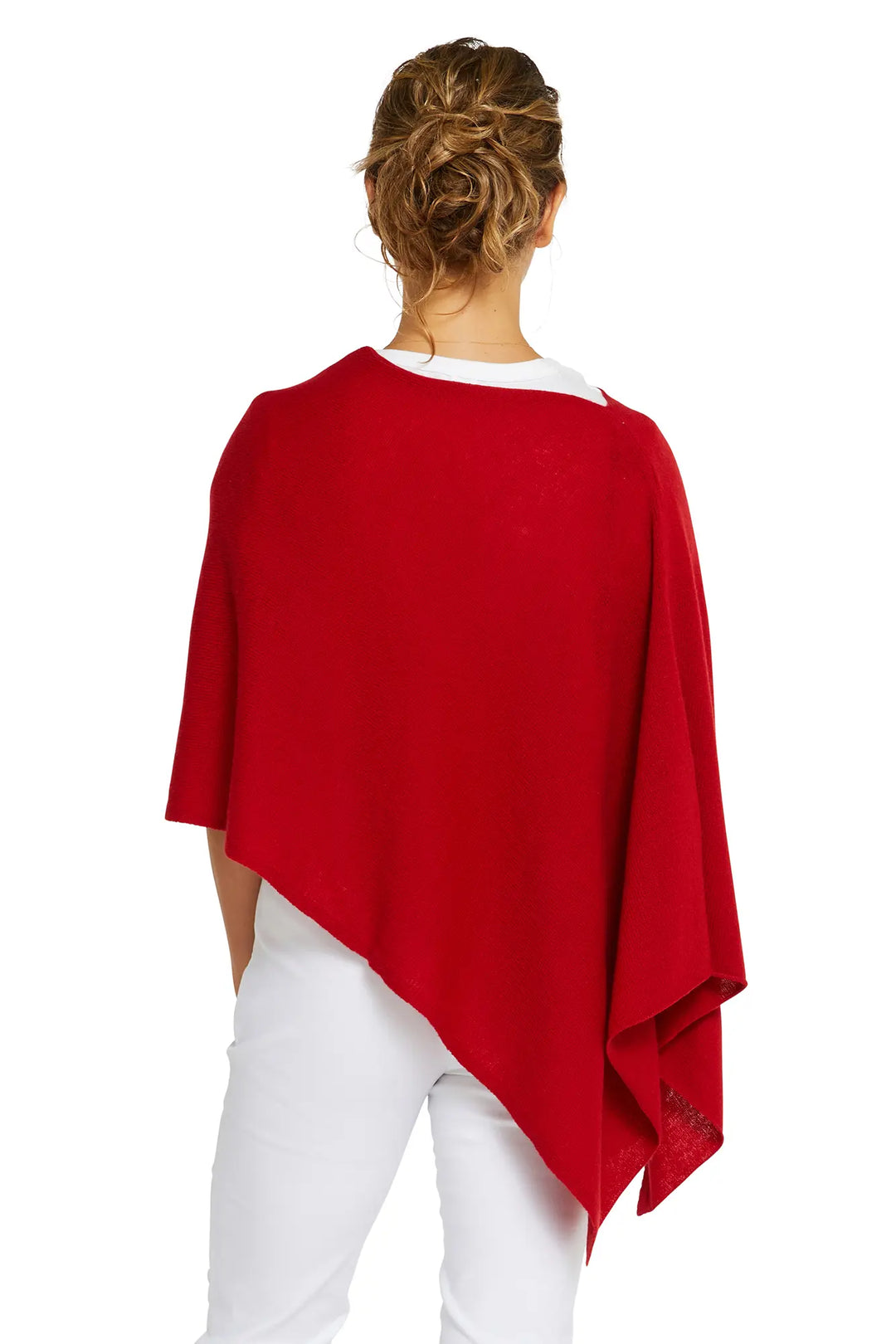 Person wearing a red poncho over a white outfit on a white background