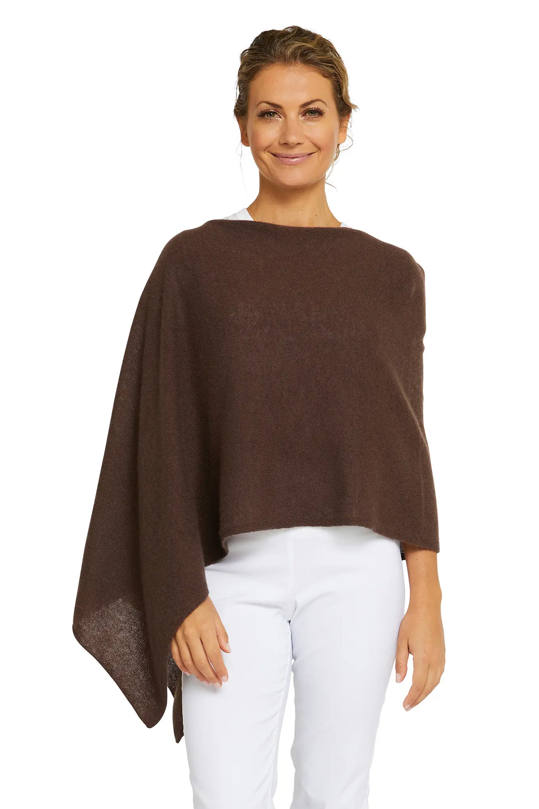 Woman wearing a brown poncho over a white top and pants on a white background