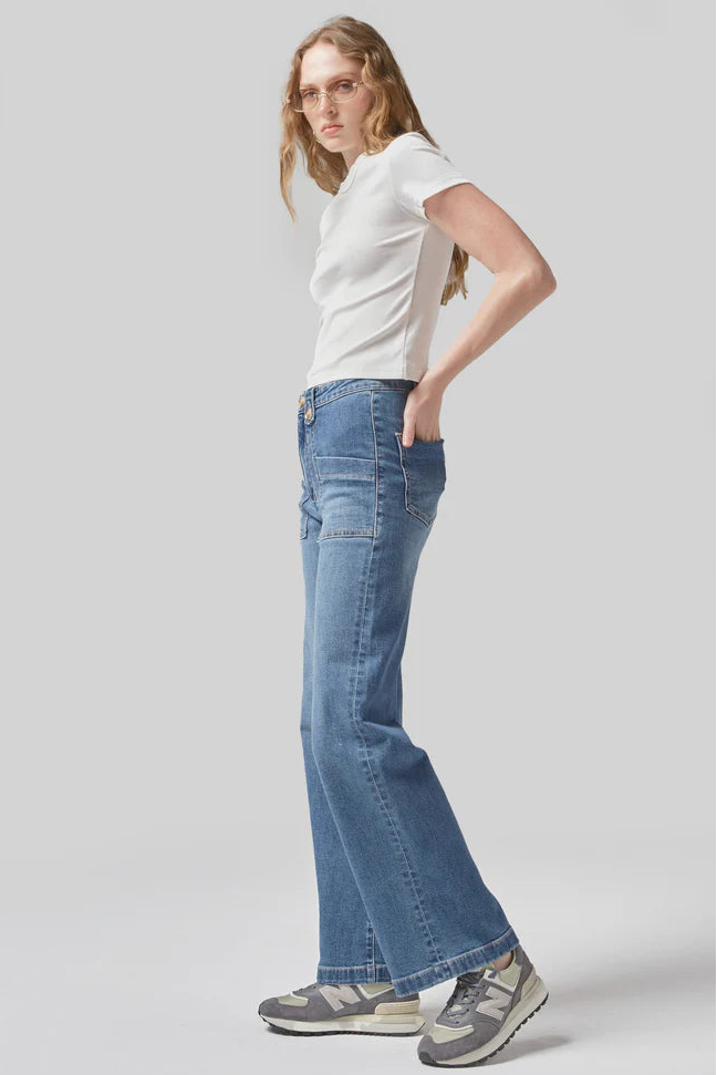 Person wearing a white t-shirt and blue jeans on a light gray background