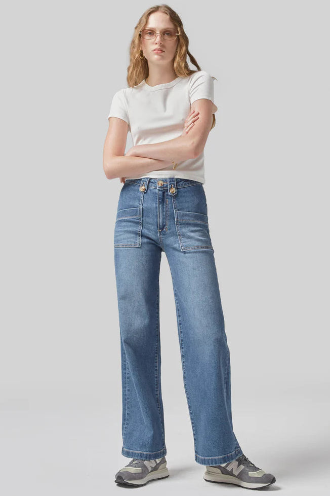 Person wearing a white t-shirt and blue jeans on a plain background