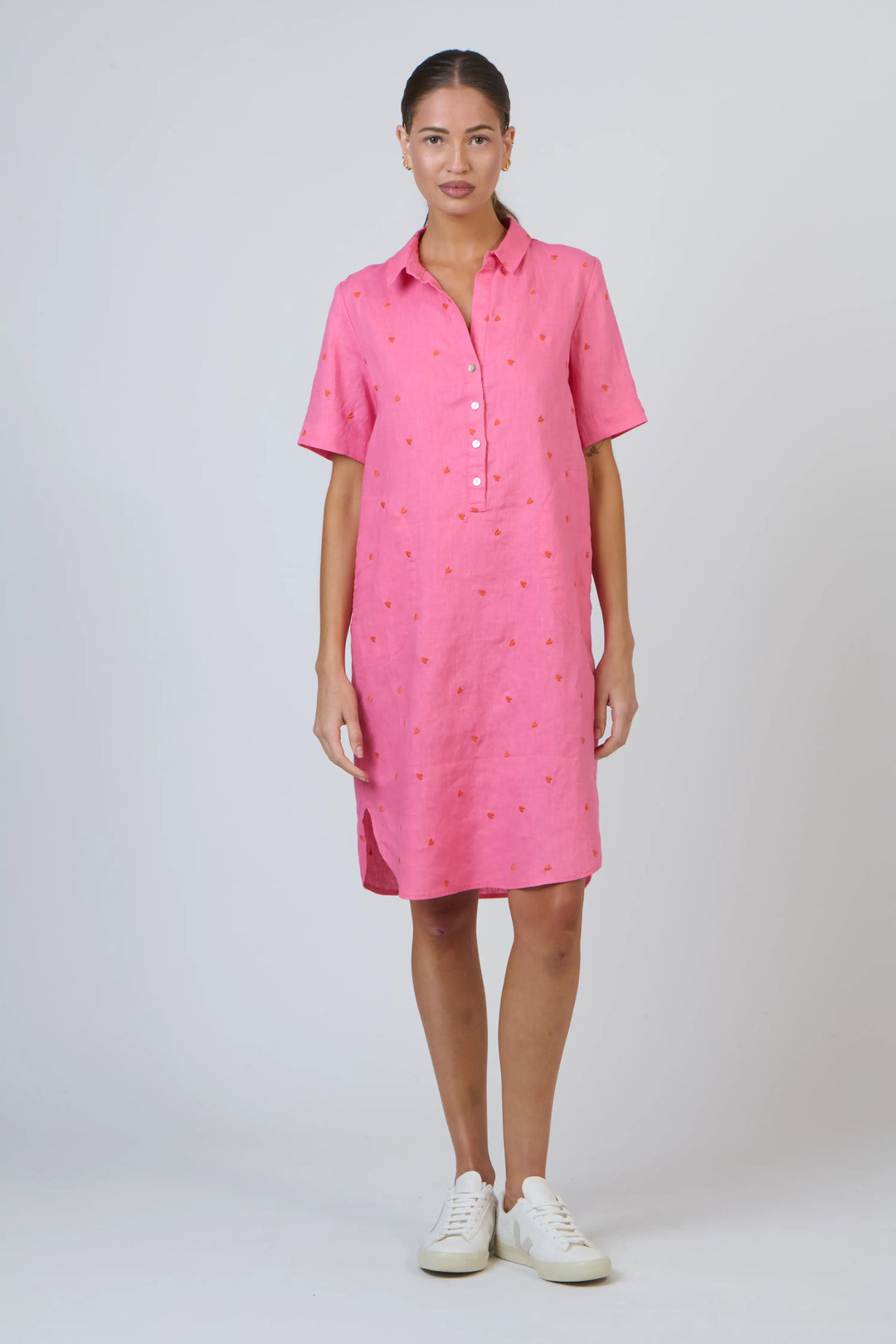 Woman wearing a pink dress with a white background