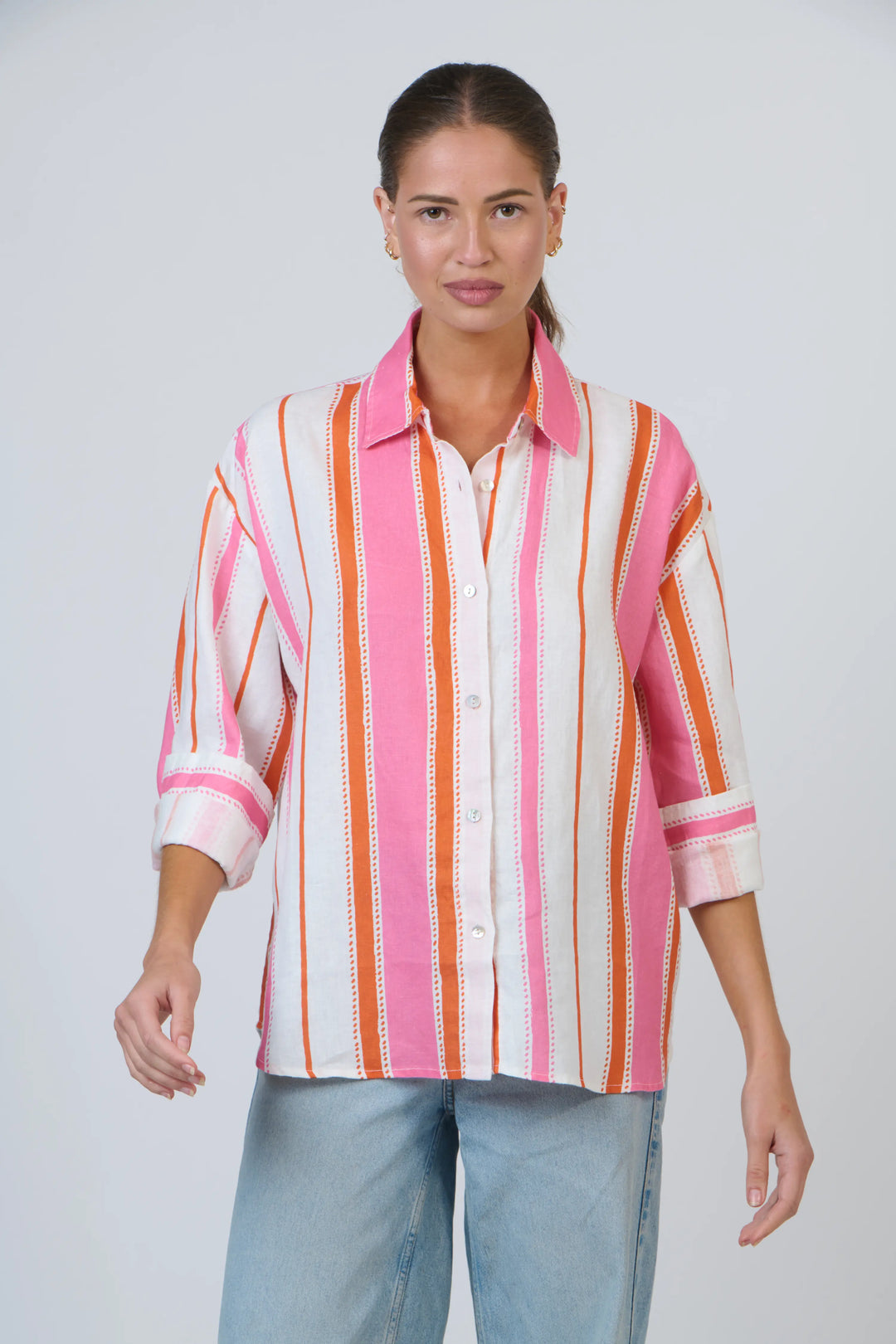 Woman wearing a colorful striped shirt against a white background