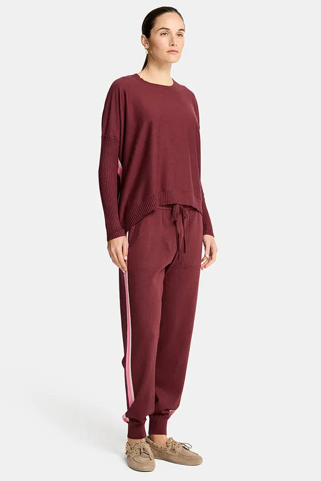 Person wearing a burgundy outfit with a white background