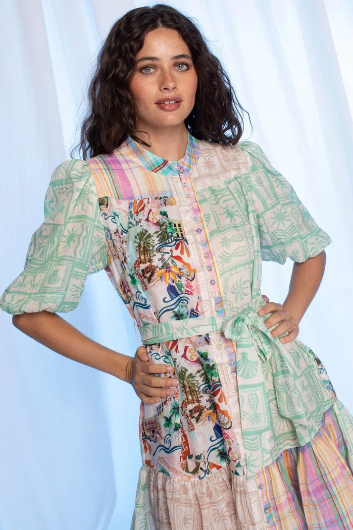 Woman wearing a colorful patterned dress against a light blue background