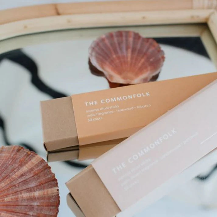 The Commonfolk product packaging with seashells on a marble surface