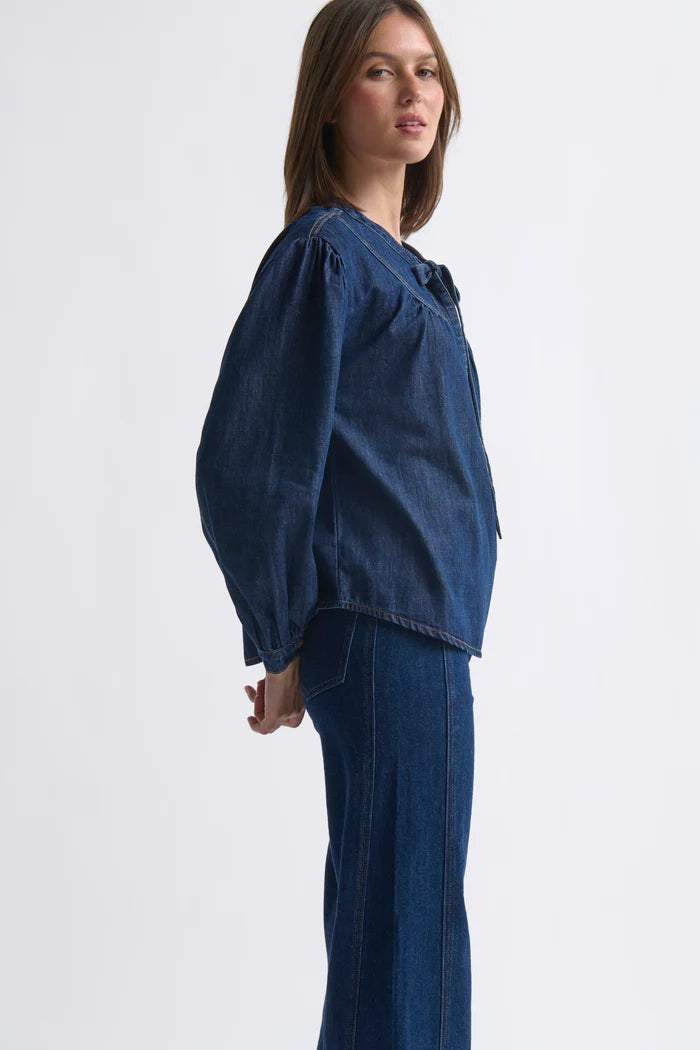 Woman wearing a blue denim outfit on a white background