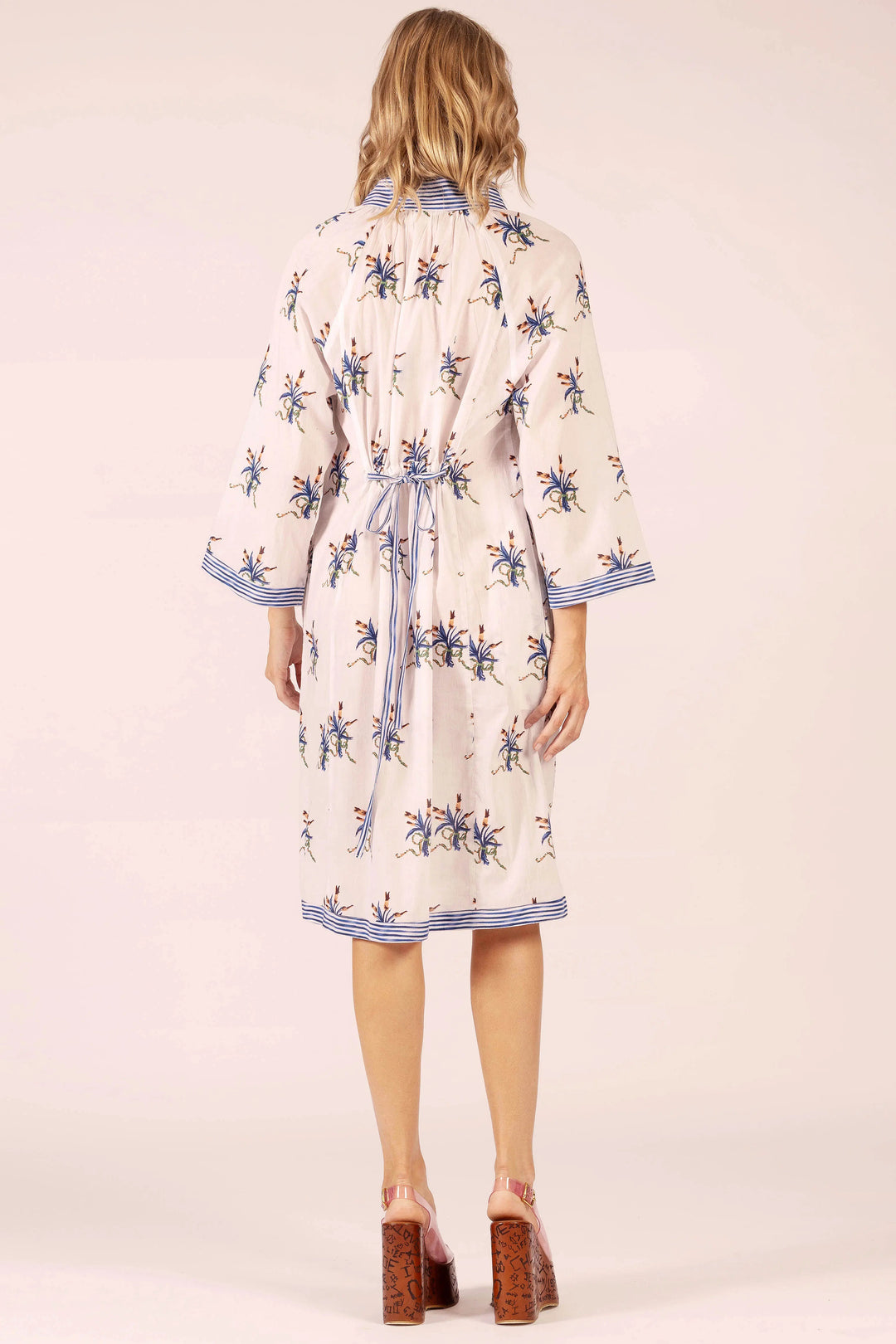 Woman wearing a floral dress with a plain background