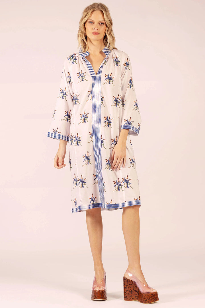 Woman wearing a floral dress with blue accents on a white background
