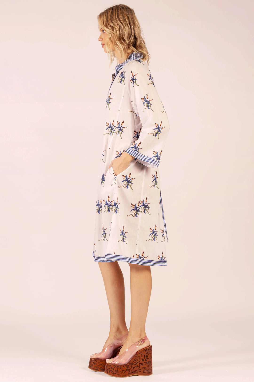 Woman wearing a patterned dress on a plain background