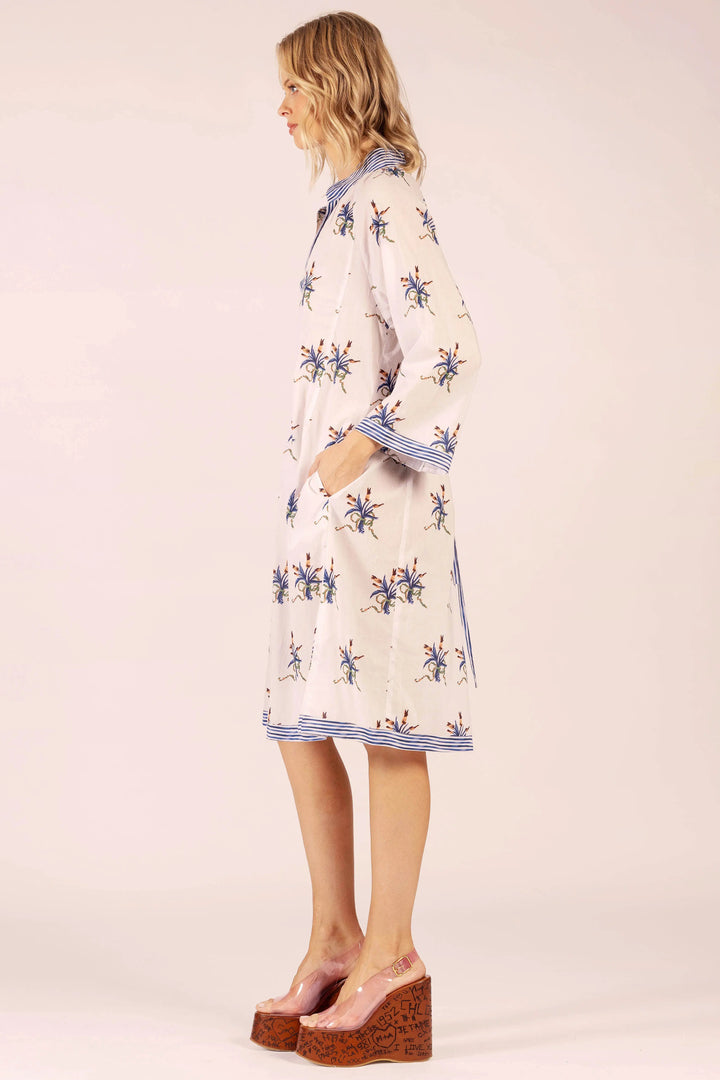 Woman wearing a patterned dress on a plain background