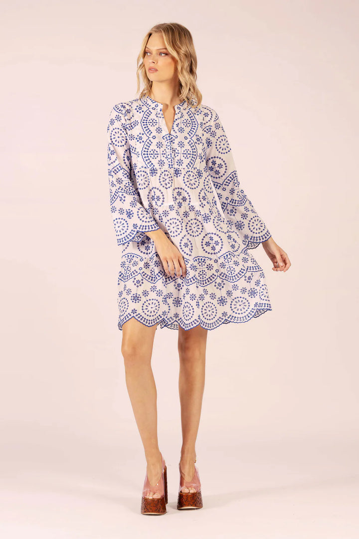 Woman wearing a blue and white patterned dress on a beige background
