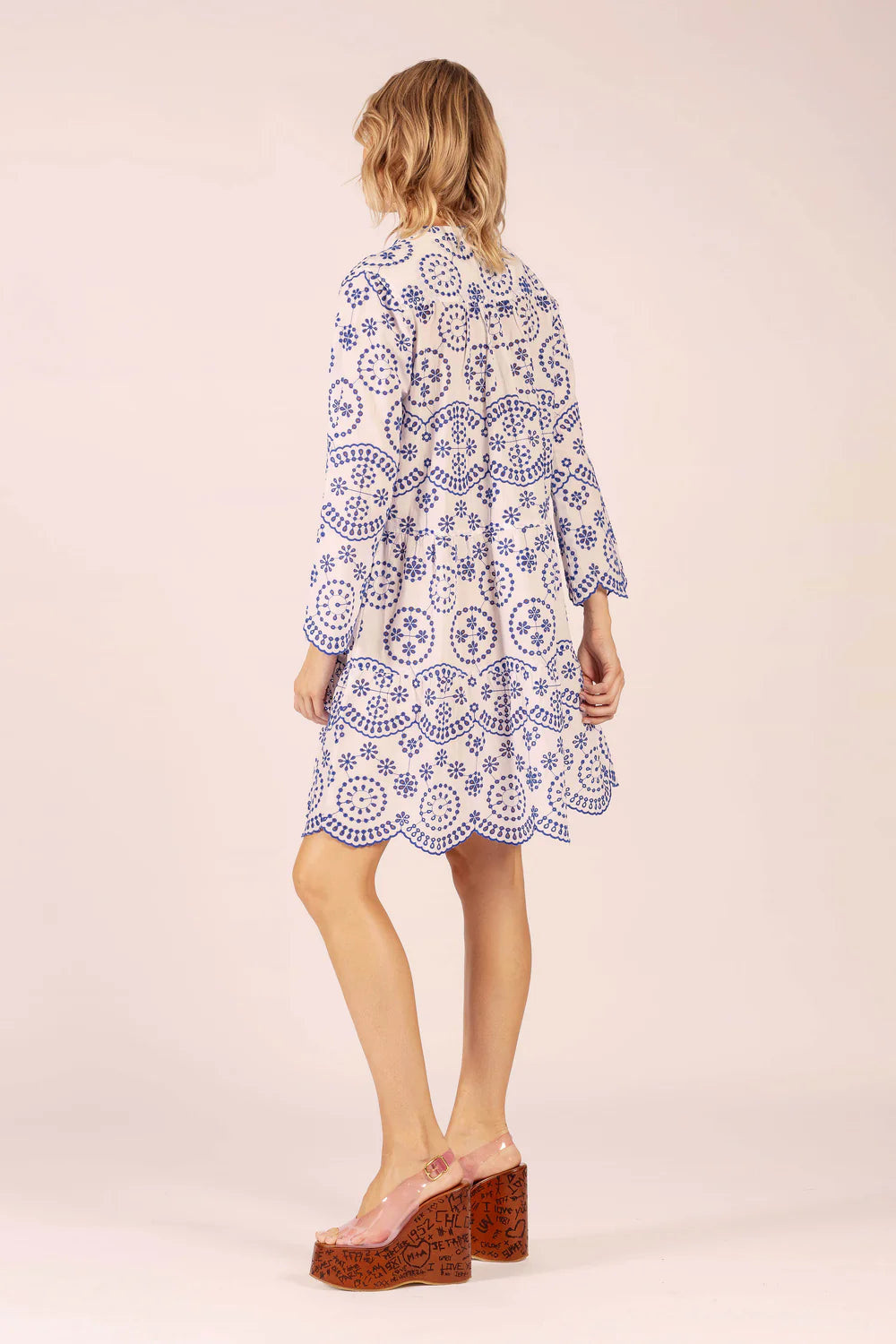 Woman wearing a patterned dress on a plain background