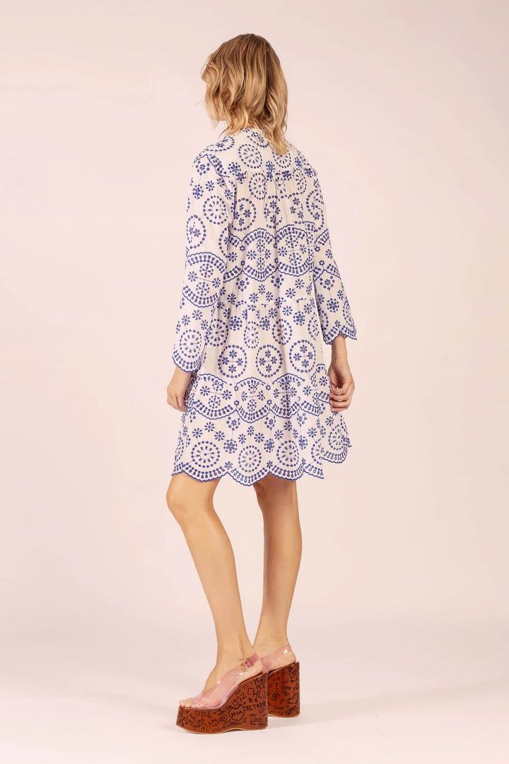 Woman wearing a patterned dress on a plain background
