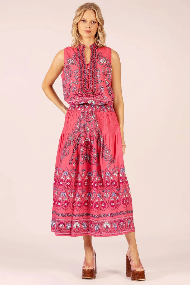 Woman wearing a pink dress with a patterned design on a white background