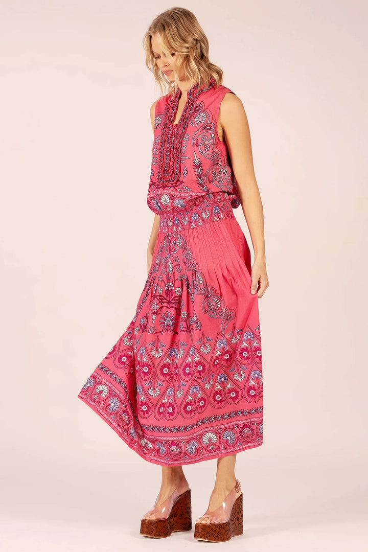Woman wearing a pink patterned dress on a white background