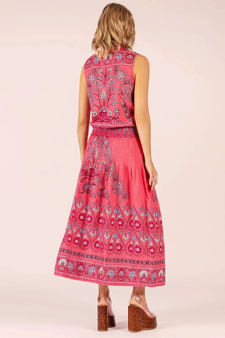 Woman wearing a pink patterned dress on a light pink background