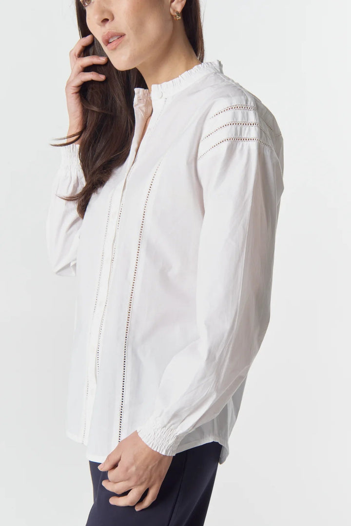 Woman wearing a white blouse with a plain background