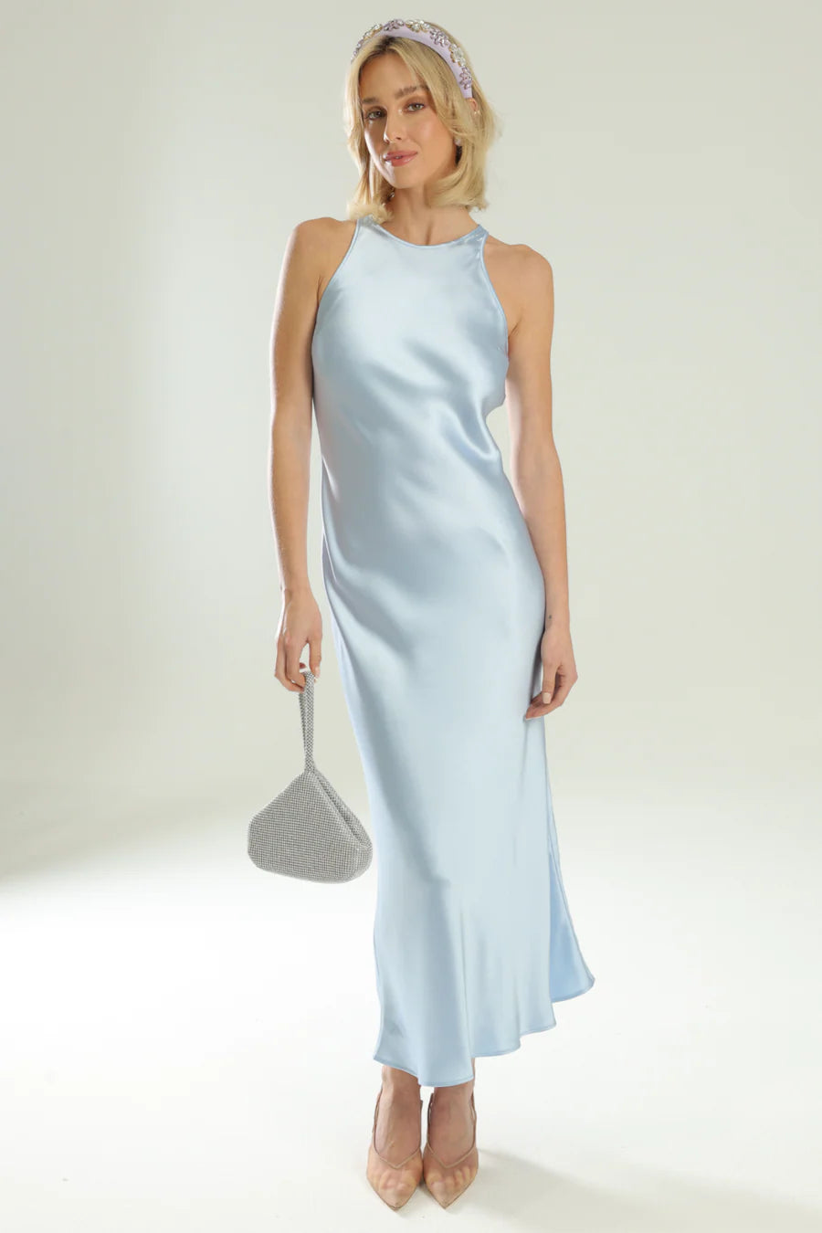 Woman wearing a light blue satin dress with a plain background
