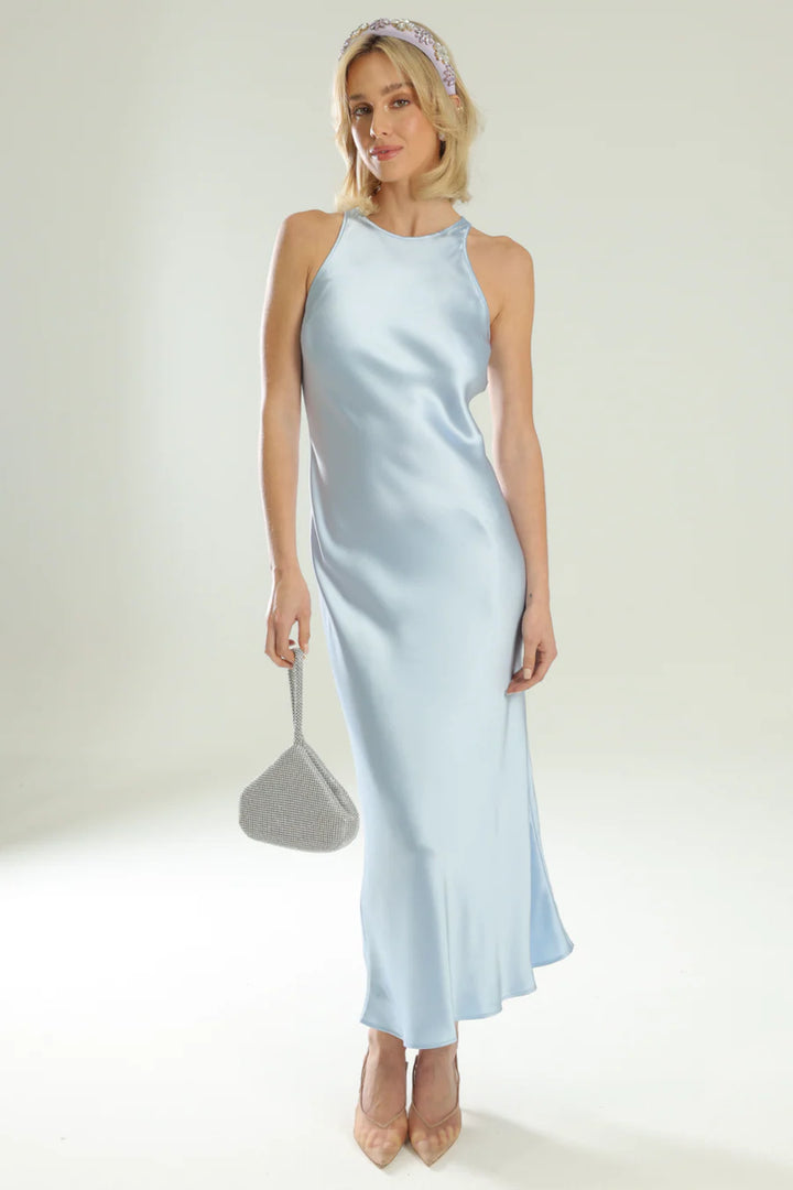 Woman wearing a light blue satin dress with a plain background