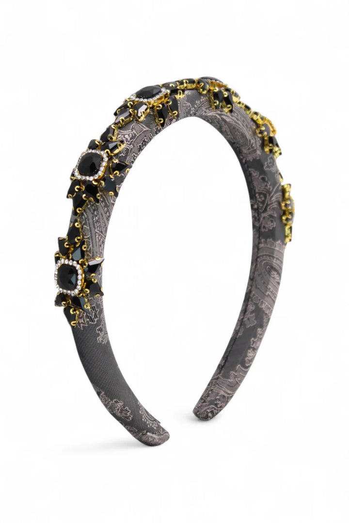 Decorative headband with black and gold accents on a white background