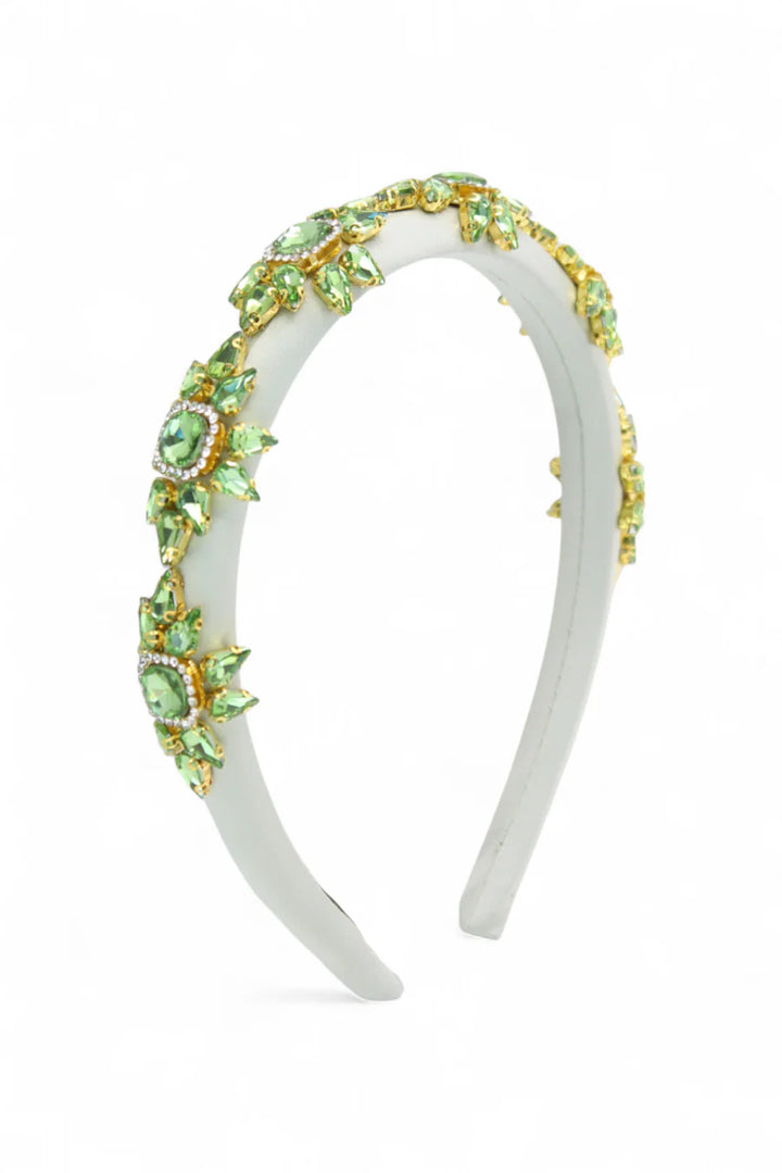 White headband with green gemstones on a white background