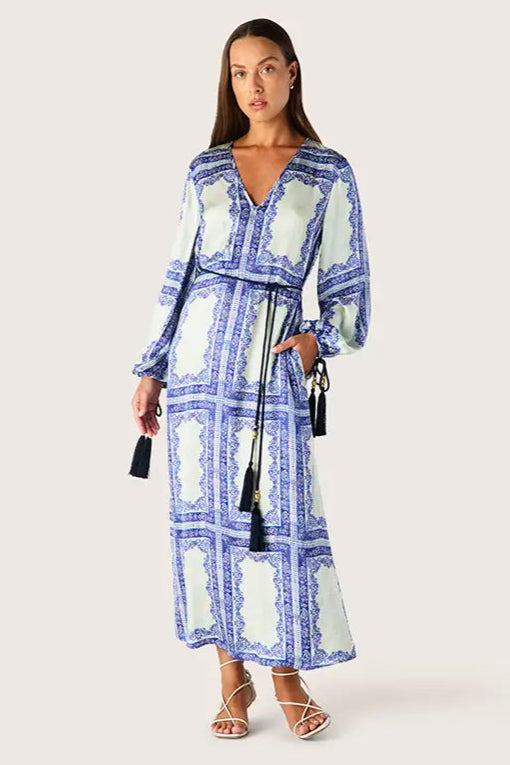 Woman wearing a blue and green patterned dress on a white background