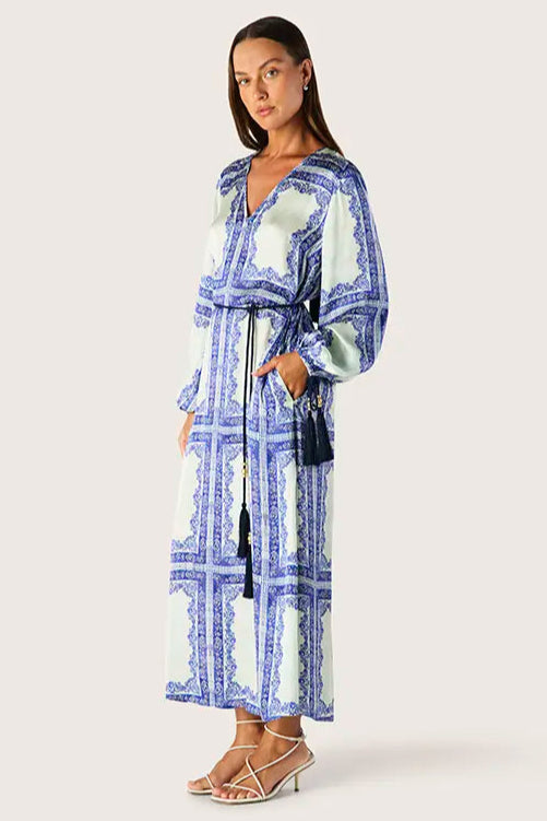 Woman wearing a blue and green patterned dress with a white background
