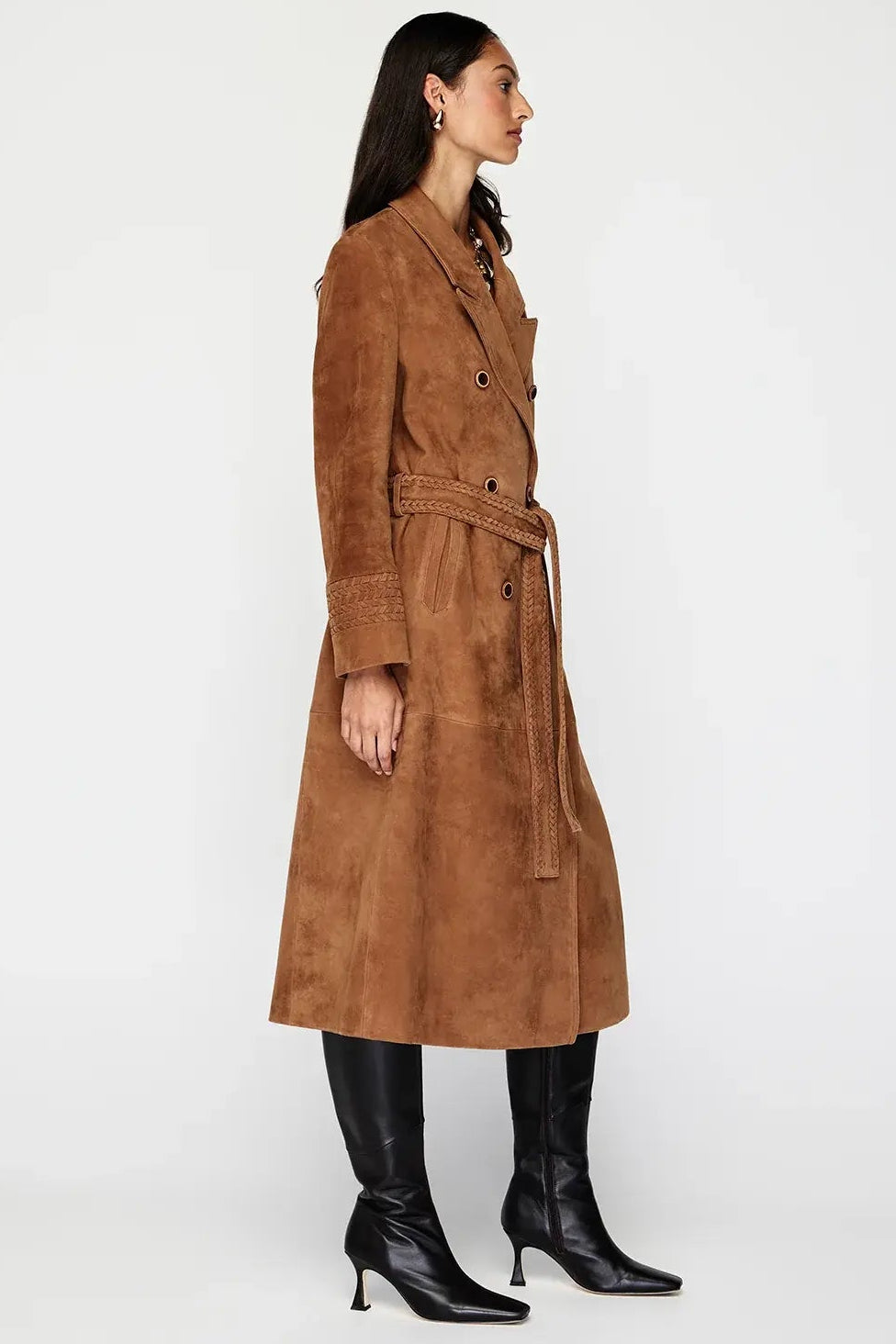 Woman wearing a brown suede trench coat on a white background