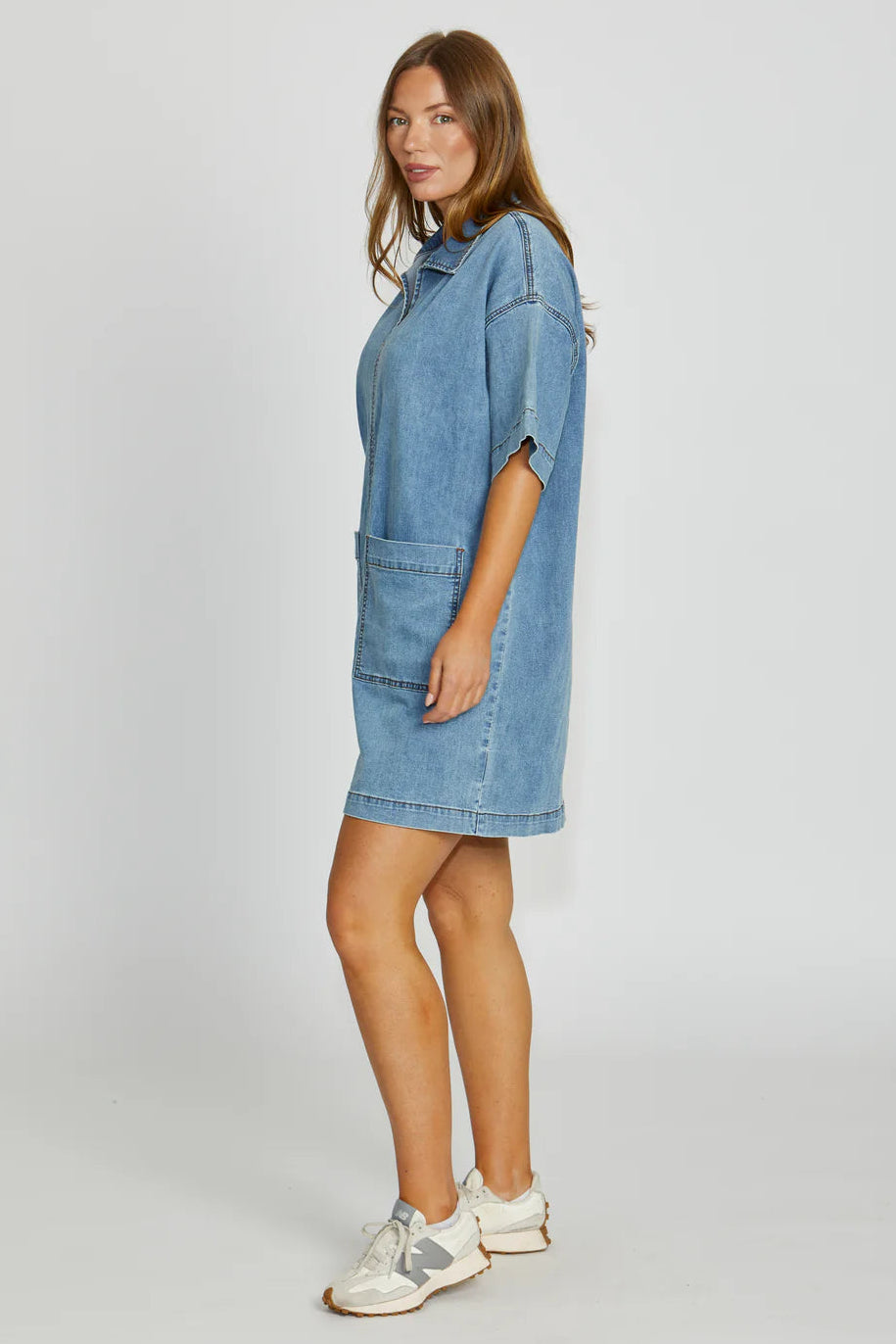 Woman wearing a blue denim dress on a white background