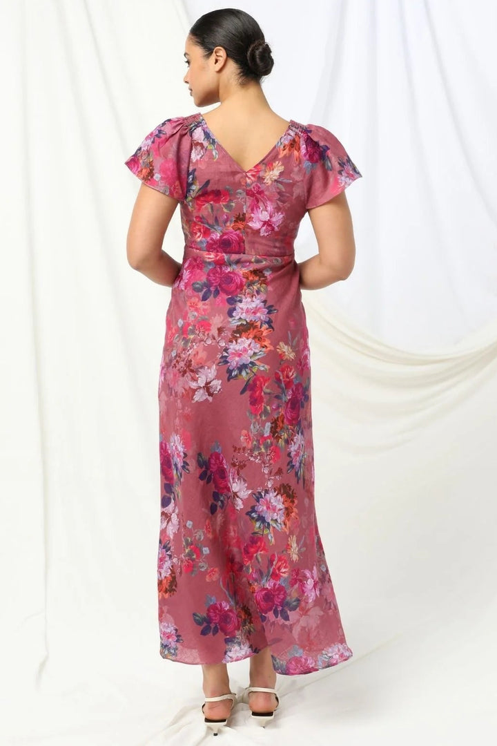 Woman wearing a pink floral dress against a white background