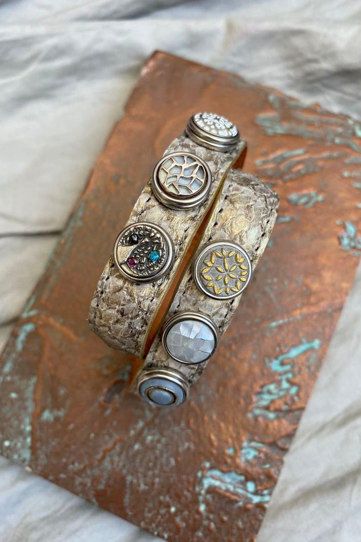 A double bracelet made of salmon skin with multiple metal chunks, displayed on a textured background.