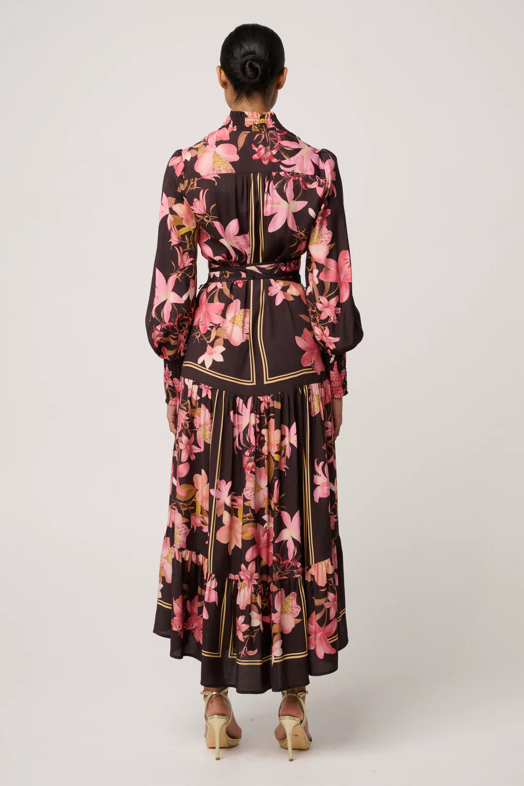 Woman wearing a floral dress with a belt on a white background