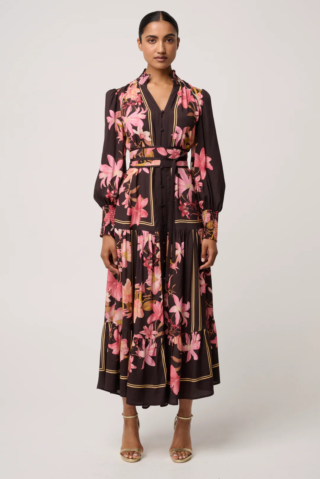 Woman wearing a black dress with pink floral pattern on a white background