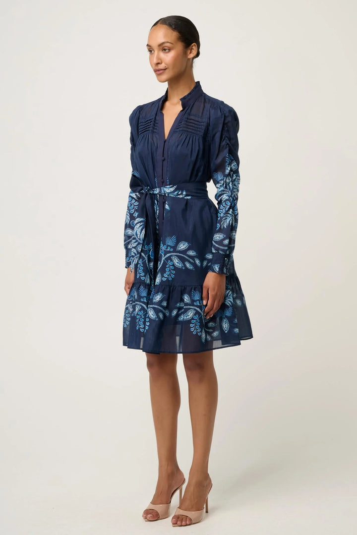 Woman wearing a navy blue dress with floral pattern on a white background
