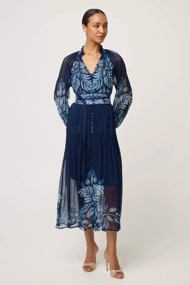 Woman wearing a navy dress with floral patterns on a white background