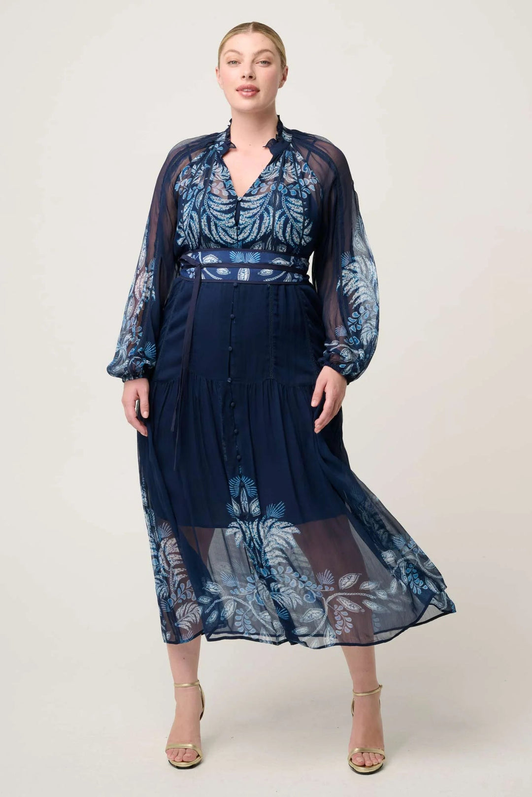 Woman wearing a navy blue floral dress on a white background