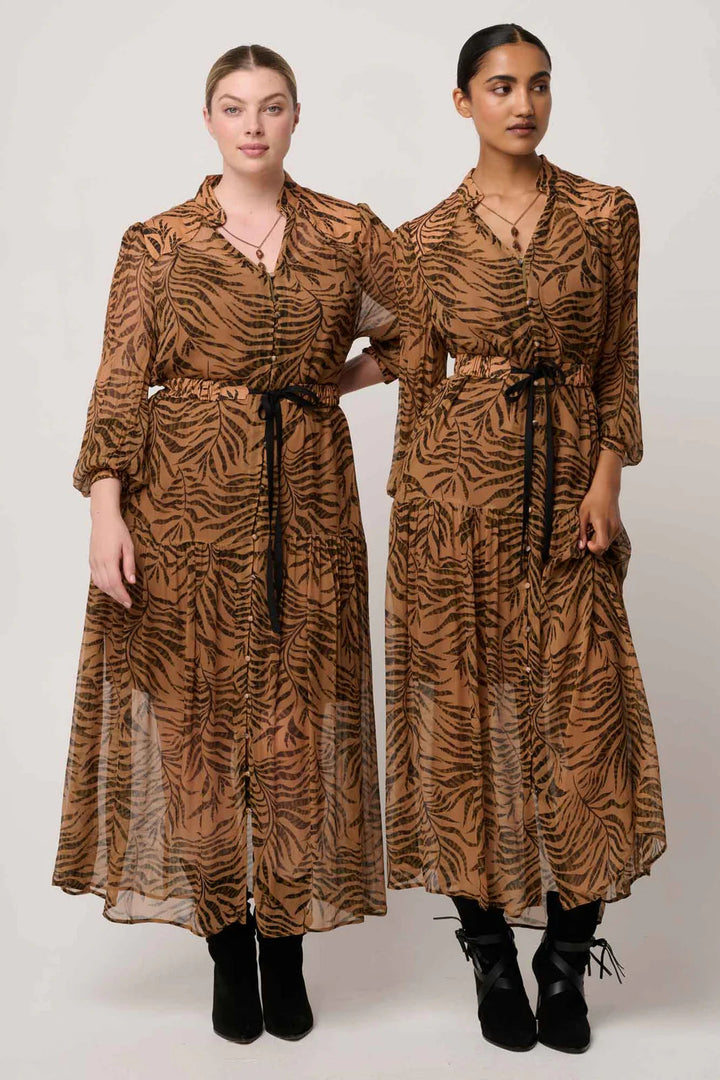 Two models wearing brown zebra print dresses on a white background