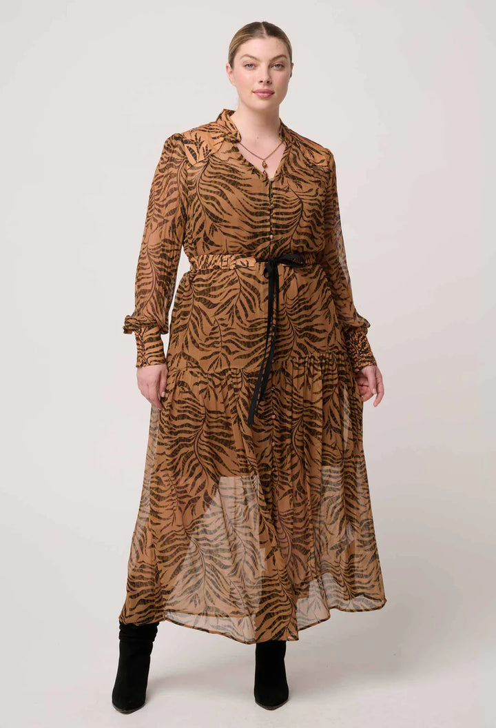 Woman wearing a long brown dress with a zebra pattern on a white background