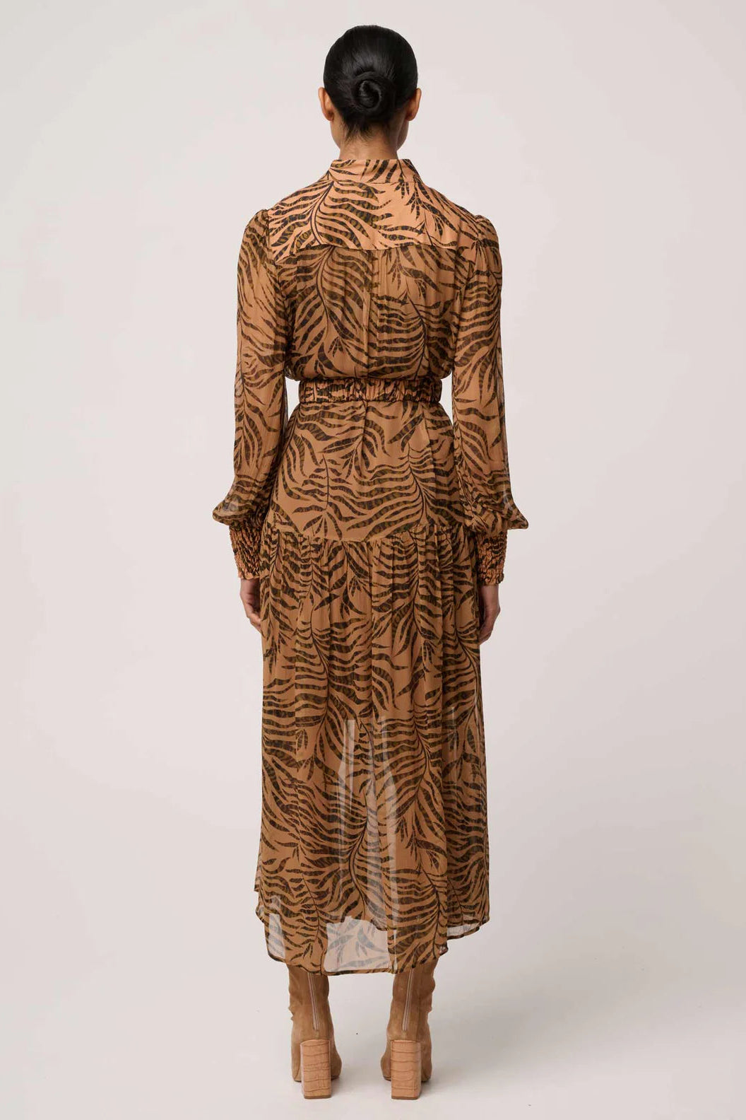 Person wearing a long, patterned dress on a white background