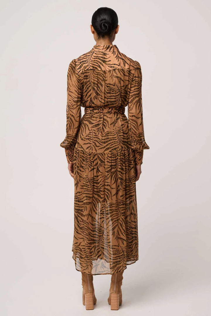 Person wearing a long, patterned dress on a white background