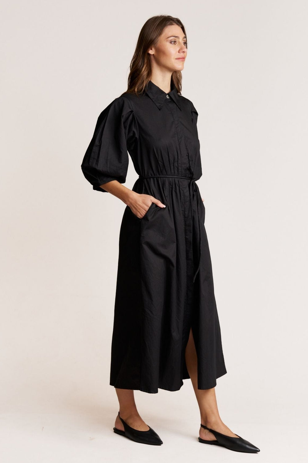Woman wearing a black dress against a plain background